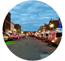 Local street event with vintage trailers lit at night near Hocking Hills