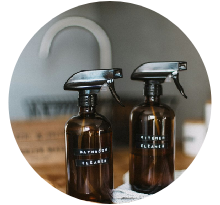 Amber glass bottles labeled bathroom cleaner on sink counter